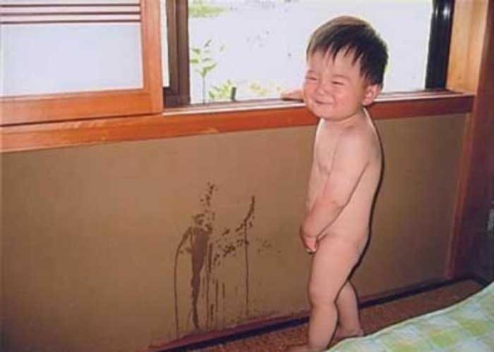 bimbo sorridente che urina sul muro